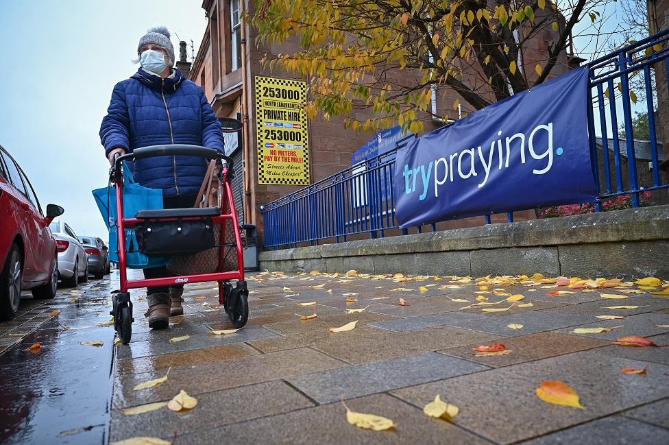 Woman with walking frame and mask