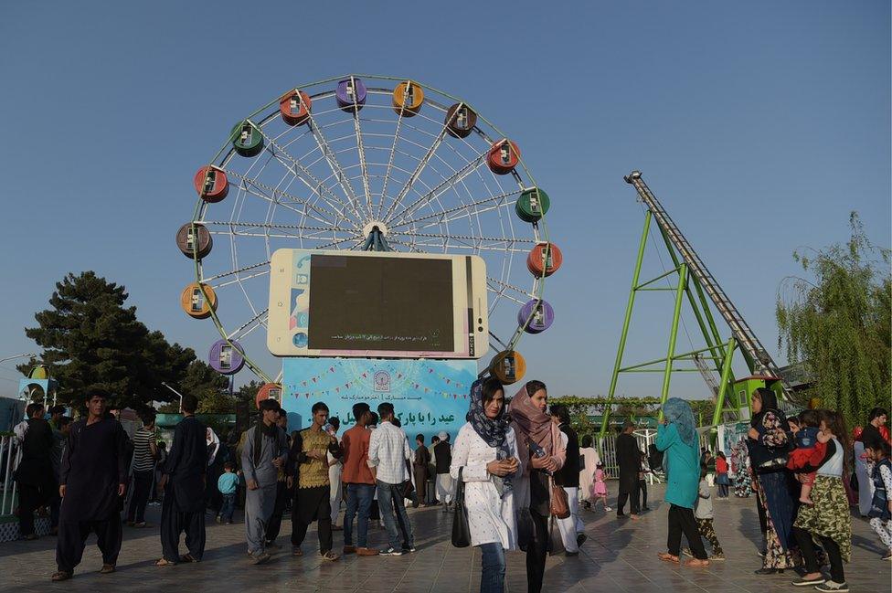 Afghan visitors walk through the Park Shahar or City Park, in Kabul on September 6, 2017.