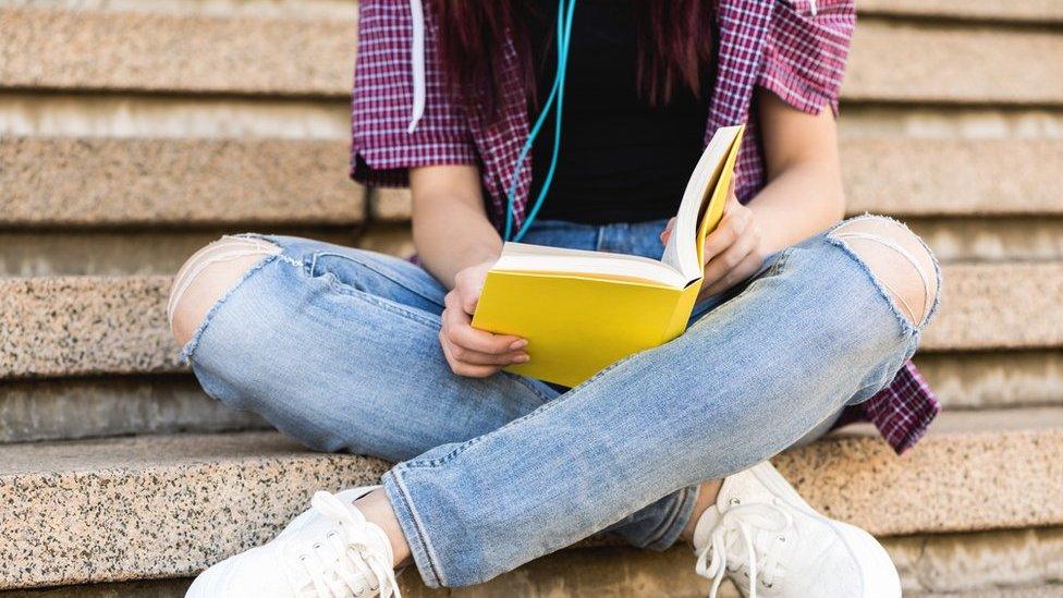 A teenage girl reading a book