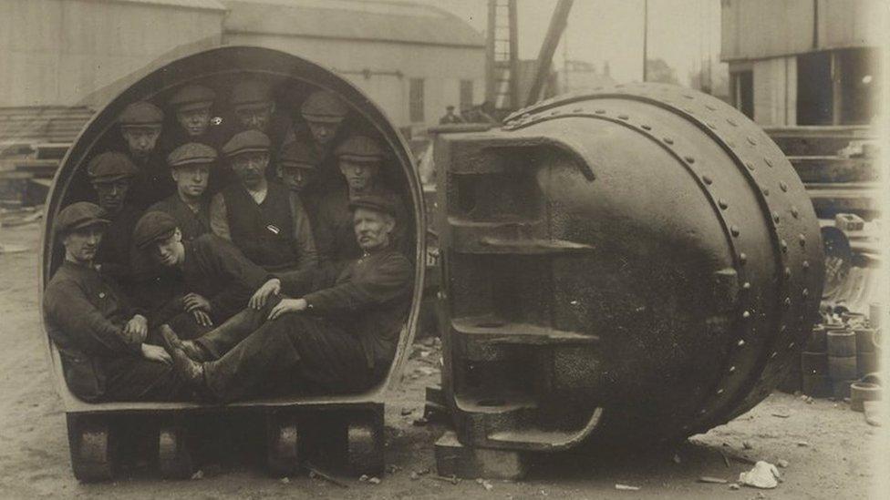 Men inside one of the mud buckets from the Corozal dredger