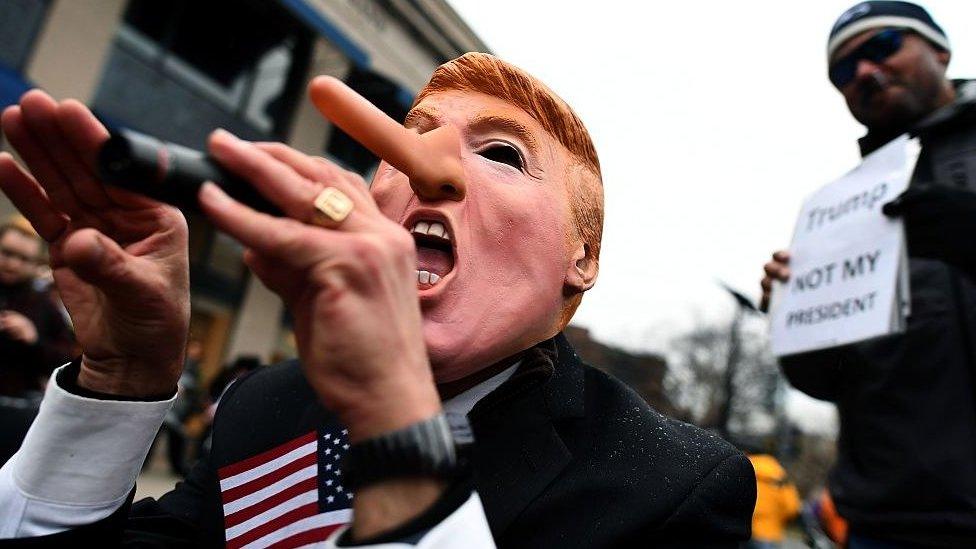 Protester in Trump mask with long nose