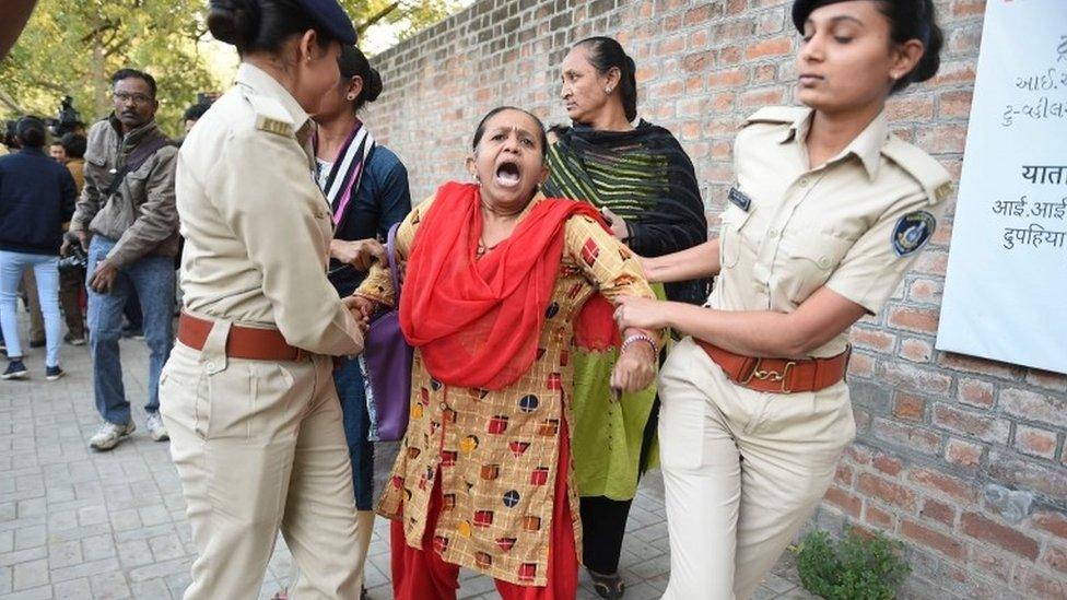 Gujarat Police officials detain a demonstrator during a protest against the Indian government's Citizenship Amendment Bill outside Indian Institute of Management (IIM) in Ahmedabad on Monday