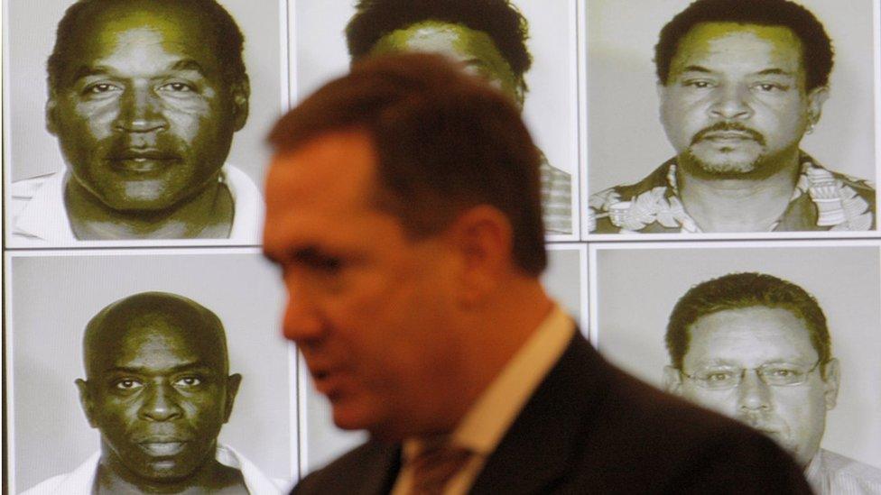 Mug shots of the alleged co-defendants are projected on the wall as Clark County District Attorney David Roger speaks as OJ Simpson appears in court at the start of closing arguments for his trial at the Clark County Regional Justice Center on October 2, 2008 in Las Vegas, Nevada