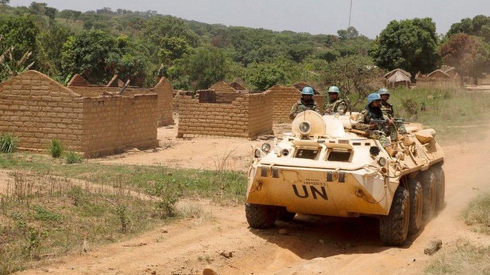 United Nations peacekeeping force vehicles drive by houses destroyed by violence in September, in the abandoned village of Yade, Central African Republic April 27, 2017