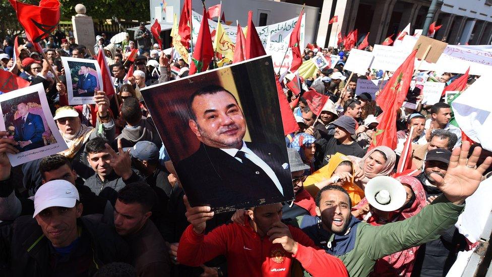 moroccan protesters lift up photos of the king