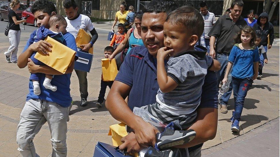 Migrant families carrying young children