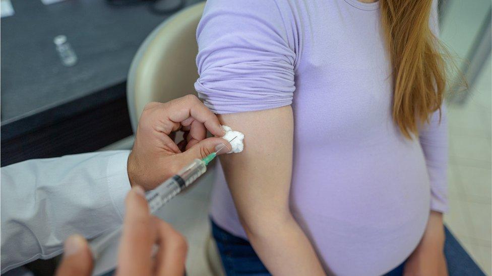 A pregnant woman getting a jab