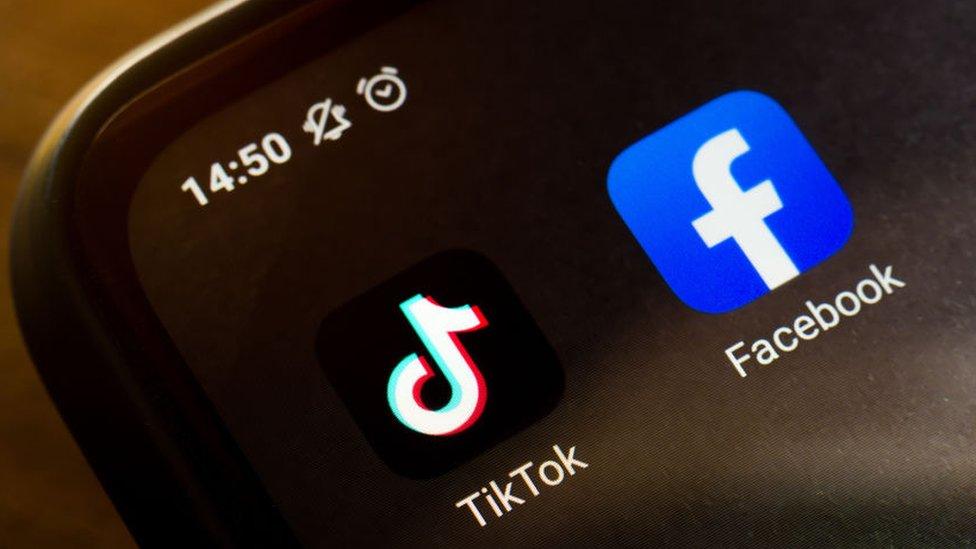 TikTok Facebook logos on a phone screen