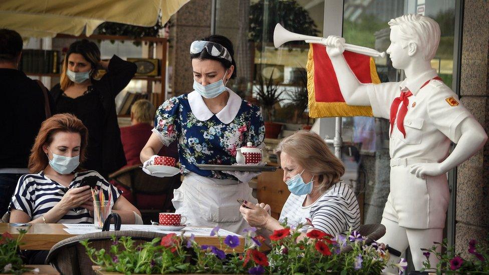 A waitress serves a meal in a Soviet style cafe in central Moscow on June 16, 2020