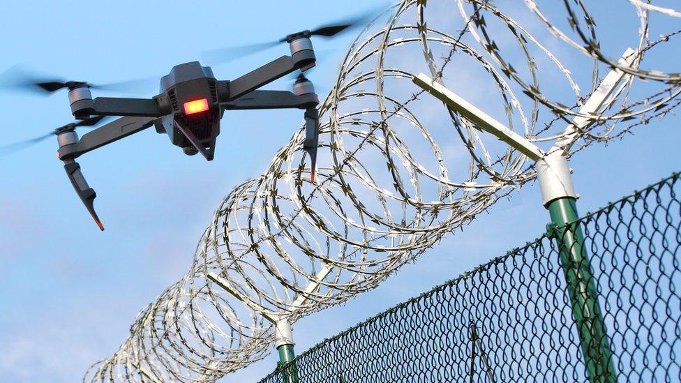 Drone monitoring barbed wire fence on state border or restricted area.