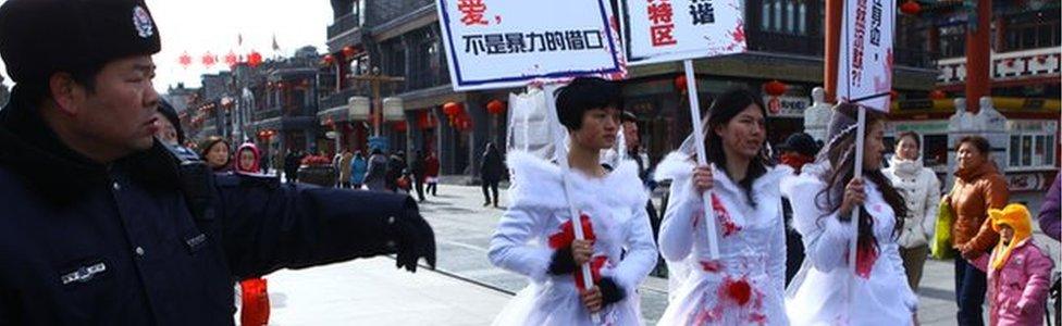 Li Tingting in the middle and two others wear paint-spattered wedding dresses