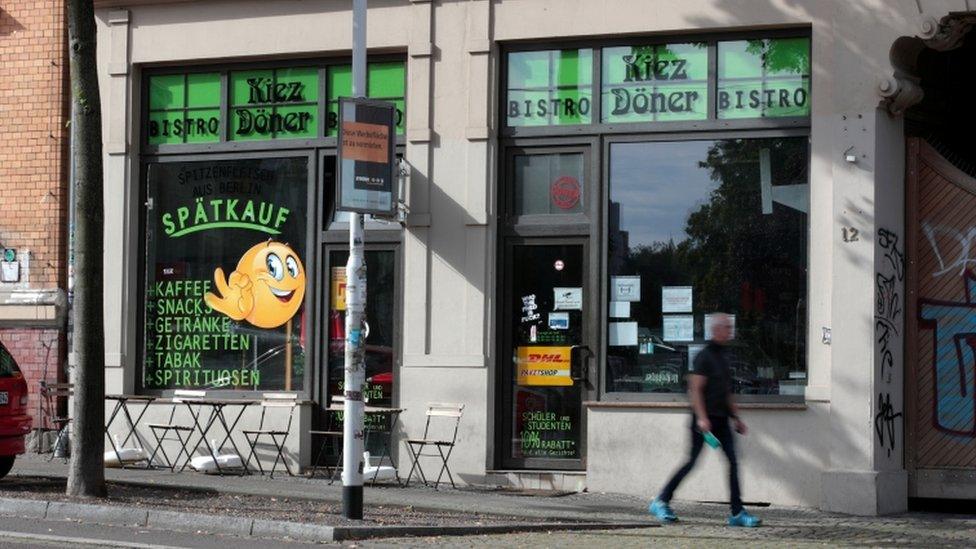 A man walks in front of a kebab shop where a person was killed in 2019 in Halle, Germany, July 28, 2020.