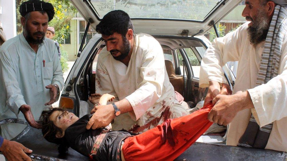 A wounded Afghan child being brought to a hospital after being injured in a mortar explosion in Kandahar on 1 July 2015