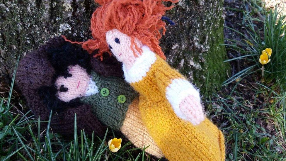 Knitted Ross and Demelza Poldark embracing at the base of a tree