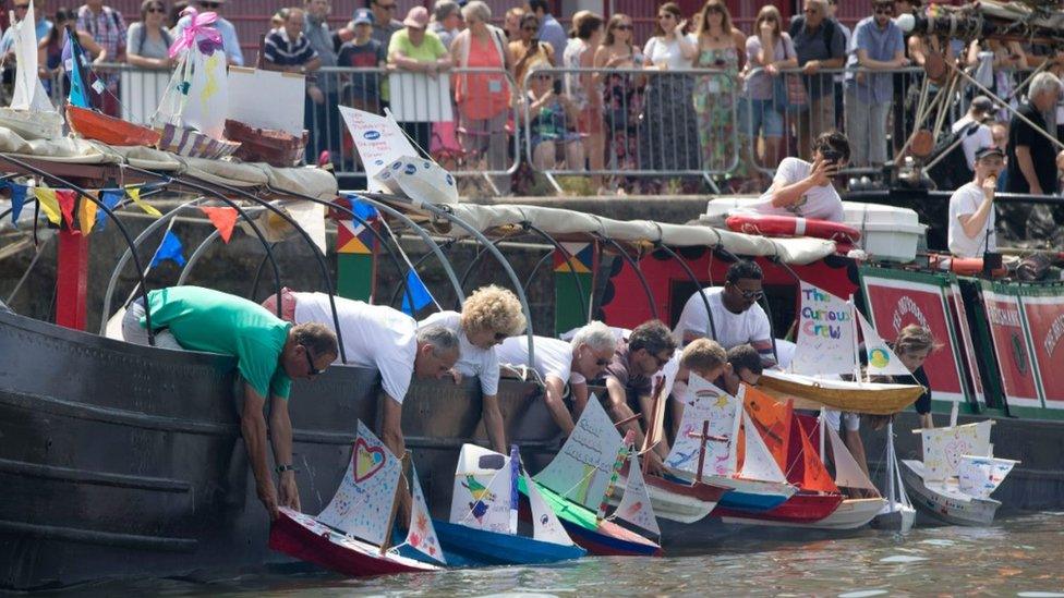 People setting off their carboard boats in the competition