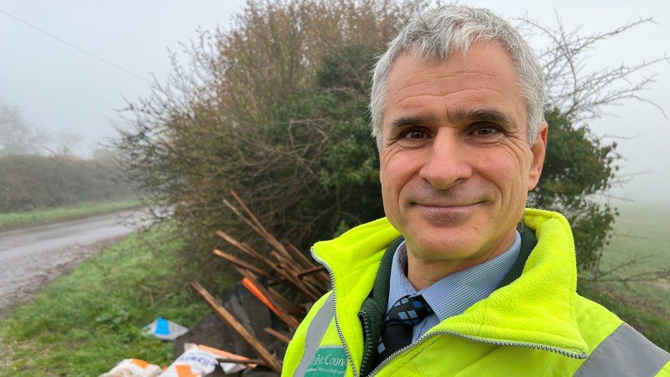 Adrian Hampton stands in front of a new dump of building materials on a rural road