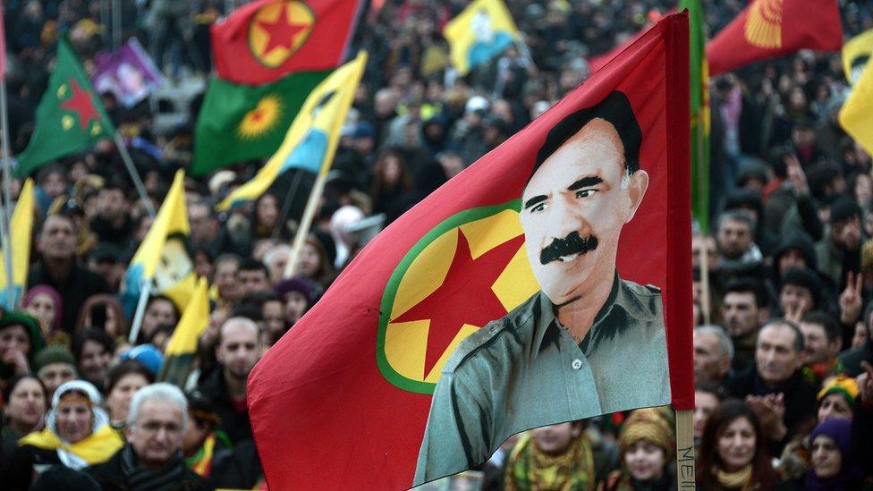 Members of the Kurdish community wave flags and banners showing the face of jailed Kurdistan Worker's Party (PKK) leader Abdullah Ocalan, during a demonstration calling for his release in Strasbourg, France, on 14 February 2015