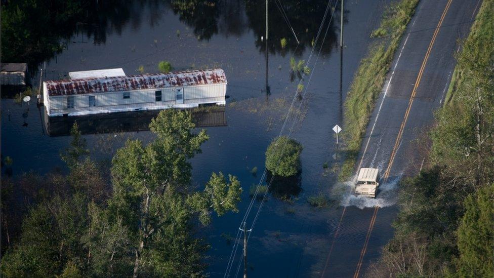 A truck drives through floodwaters