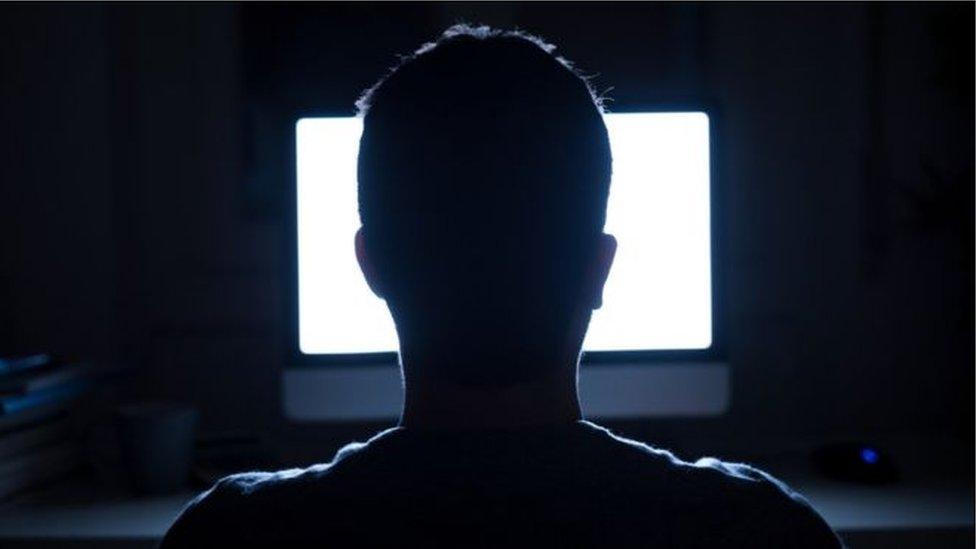 Man sits in front of computer