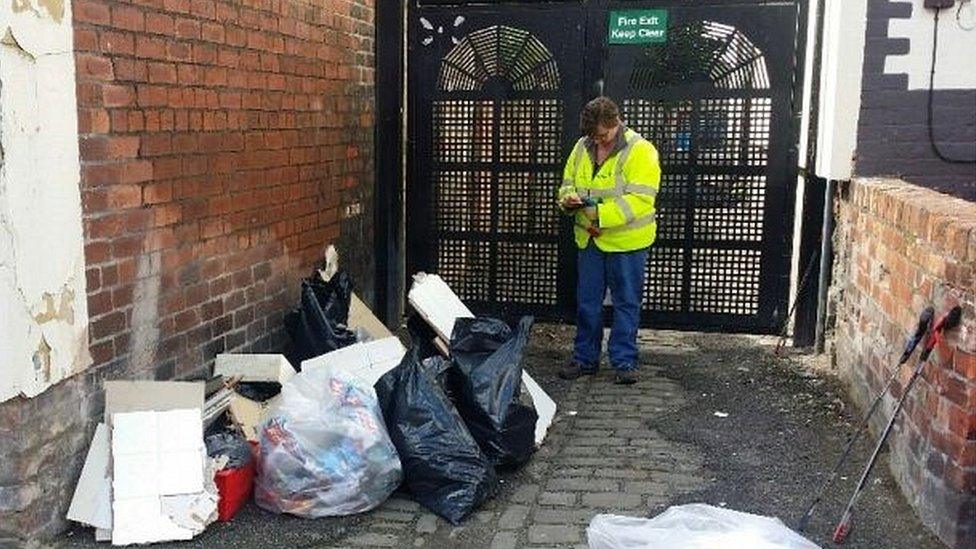 Litter-picker with discarded waste in alley