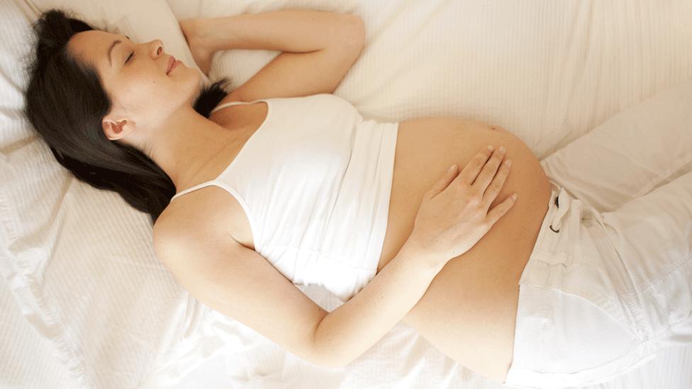 Pregnant woman sleeping on her side