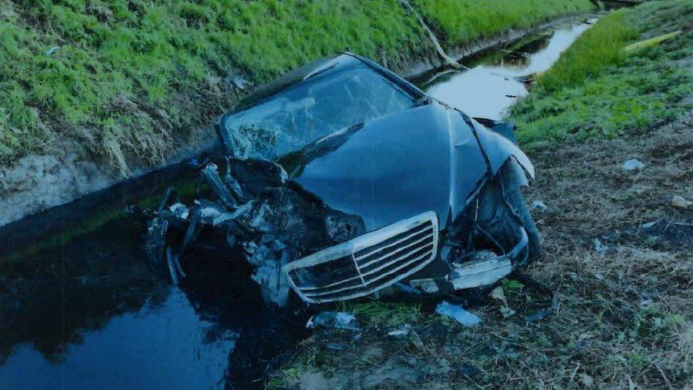 Crashed car in a ditch with water