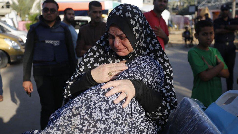 Women cry at the funeral for Wael Al-Dahdouh's family members