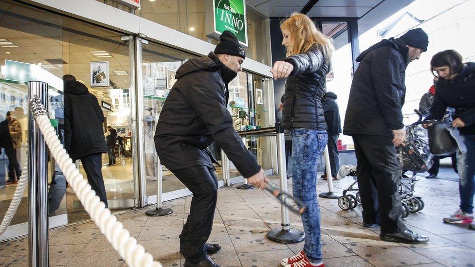 Security staff search people outside a store in Brussels, on 26 November 2015