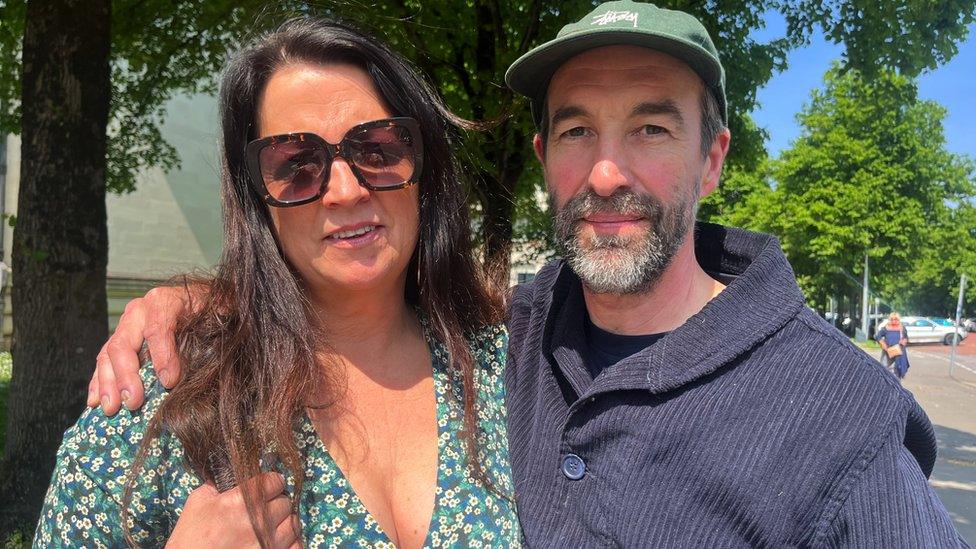 The Hardwick's owners Joanne and Stephen Terry outside Cardiff Crown Court. Joanne, a middle-aged woman with shoulder length dark hair, is wearing sunglasses. Stephen, a middle-aged man with a beard and wearing a baseball cap, has his arm around Joanne's shoulders.