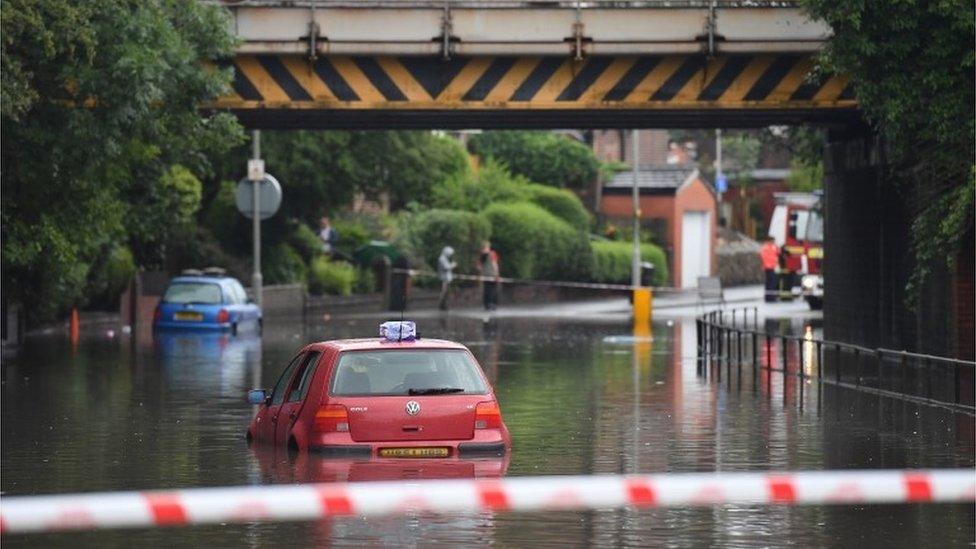 A car stranded in flood water in Crossley Road in Manchester