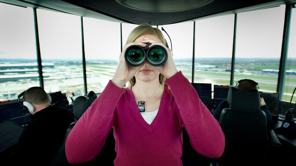 Air traffic controller holding binoculars