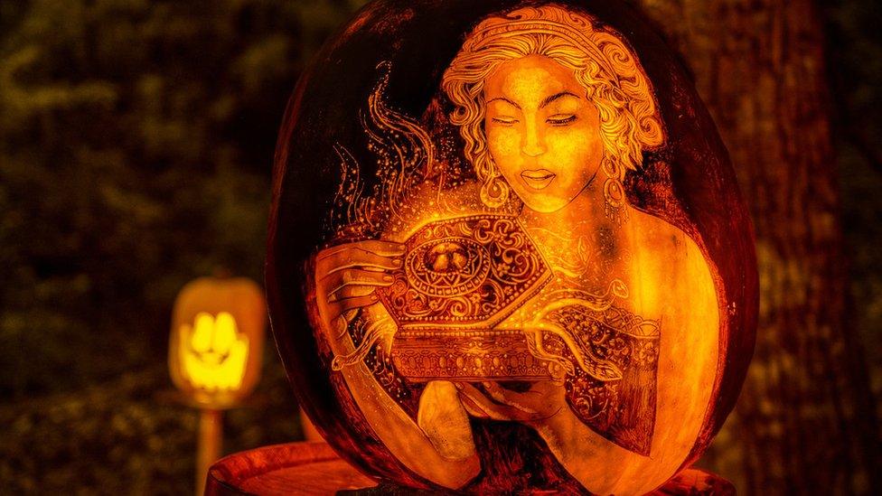 A glowing pumpkin shows a lady opening a decorated box.