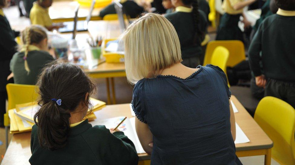 A female teacher helps a student