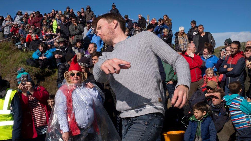 Competitors taking part in the World Stone Skimming Championships on Easdale island. Easdale was Scotland's smallest permanently-inhabited inner Hebridean island with a permanent population of around 60 people in 2019. It was the location of the annual competition which was held every September in one of the flooded former slate quarries on the island.