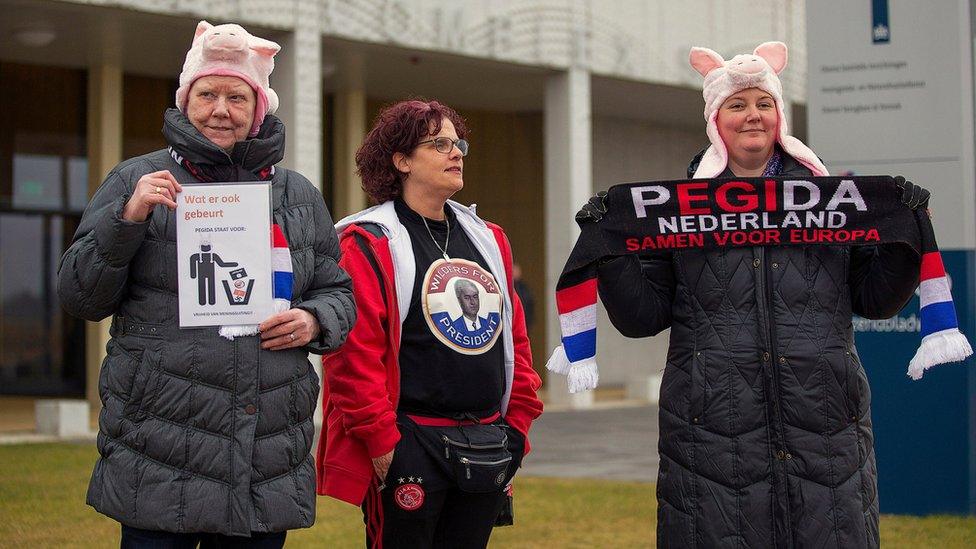 Dutch Pegida and Geert Wilders supporters stand outside the courthouse in Schiphol, the Netherlands March 18, 2016. The sign on a scarf reads "The Netherlands together for Europe" and the other one "Whatever happens, Pegida stands for freedom of speech"