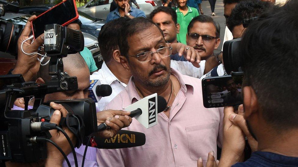 Indian Bollywood actor Nana Patekar is mobbed by the media as he leaves his home in Mumbai on October 8, 2018.