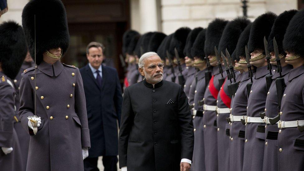 Narendra Modi inspecting soldiers, with David Cameron visible in the background