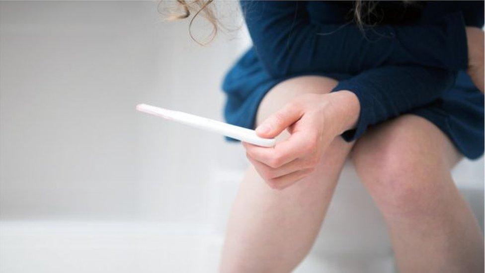 Woman holding pregnancy test