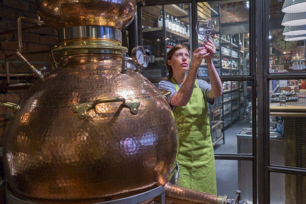 A woman working in a gin distillery