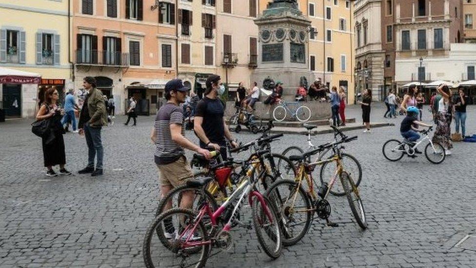 Cyclists stop in the Camp di Fiori square in central Rome, Italy. Photo: 16 May 2020