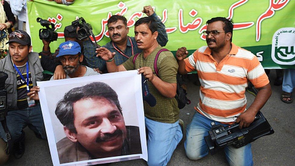 Pakistani journalists in Karachi hold a picture of Ahmed Noorani, a senior journalist of a local newspaper who was beaten by unknown attackers (30 October 2017)