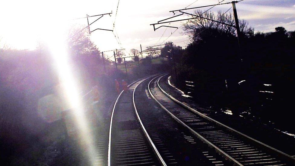 Workers flee the track in front of the train