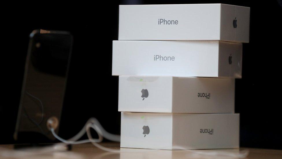 Boxes of the new iPhone X are stacked on top of one another next to a display item in an Apple Store.