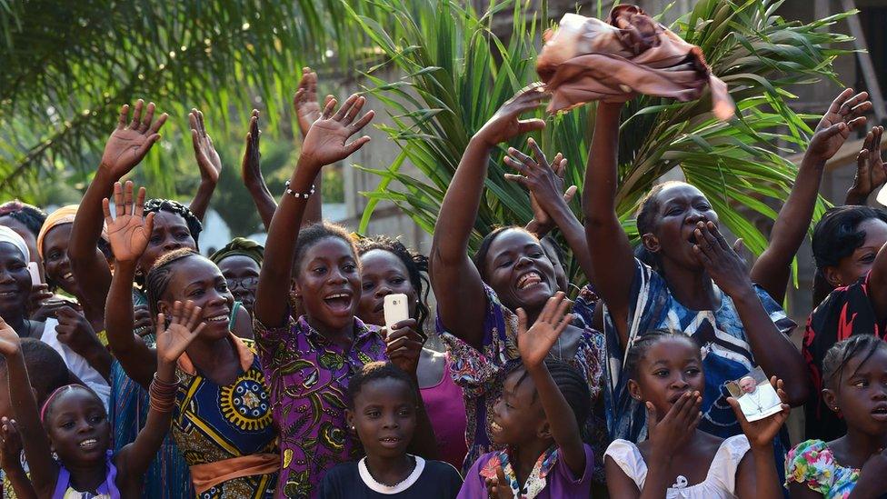 People react during the visit of Pope Francis at the Evangelic community in Bangui