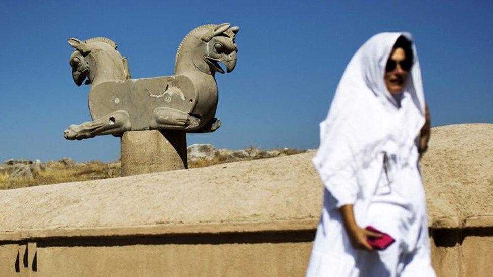 A Spanish tourist walks past an Achaemenid griffin at the ancient Persian city of Persepolis