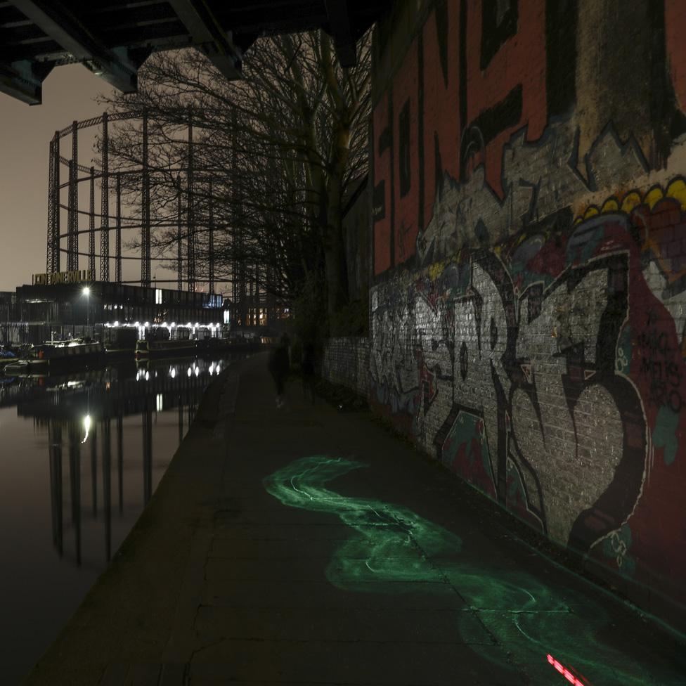 Gasometer and graffiti on a wall on Regent's Canal in London