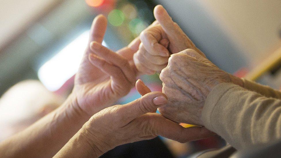 Patient and nurse holding hands