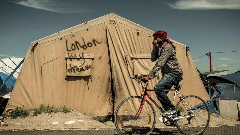 This file photo taken on June 24, 2016, shows a migrant riding his bicycle inside the "Jungle" camp for migrants and refugees in Calais, the day after Britain voted to leave the EU.