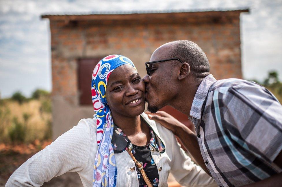 Julius kisses his wife on the cheek.