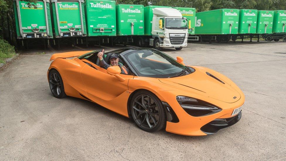 Andrew Olsen in a McLaren 720S Spider in front of a row of HGV lorries